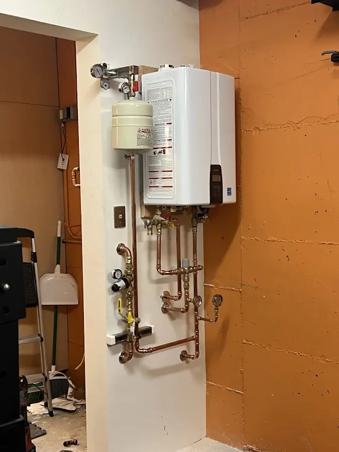 Plumbing technician inspecting water heater connections in Nassau